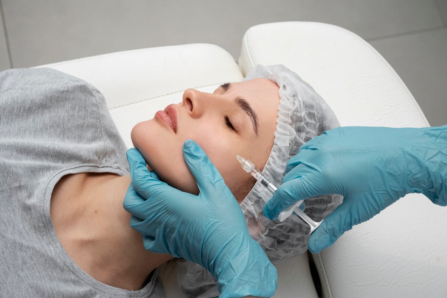 Patient receiving an aesthetic injection treatment at a medical clinic.