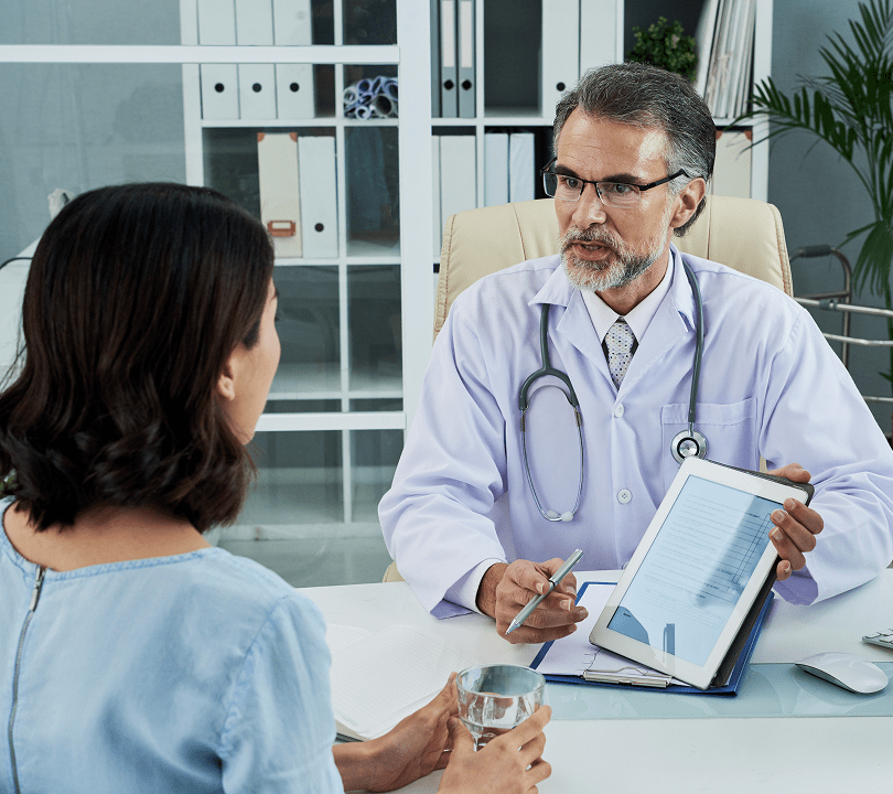 Doctor showing diagnosis results on tablet during patient consultation.