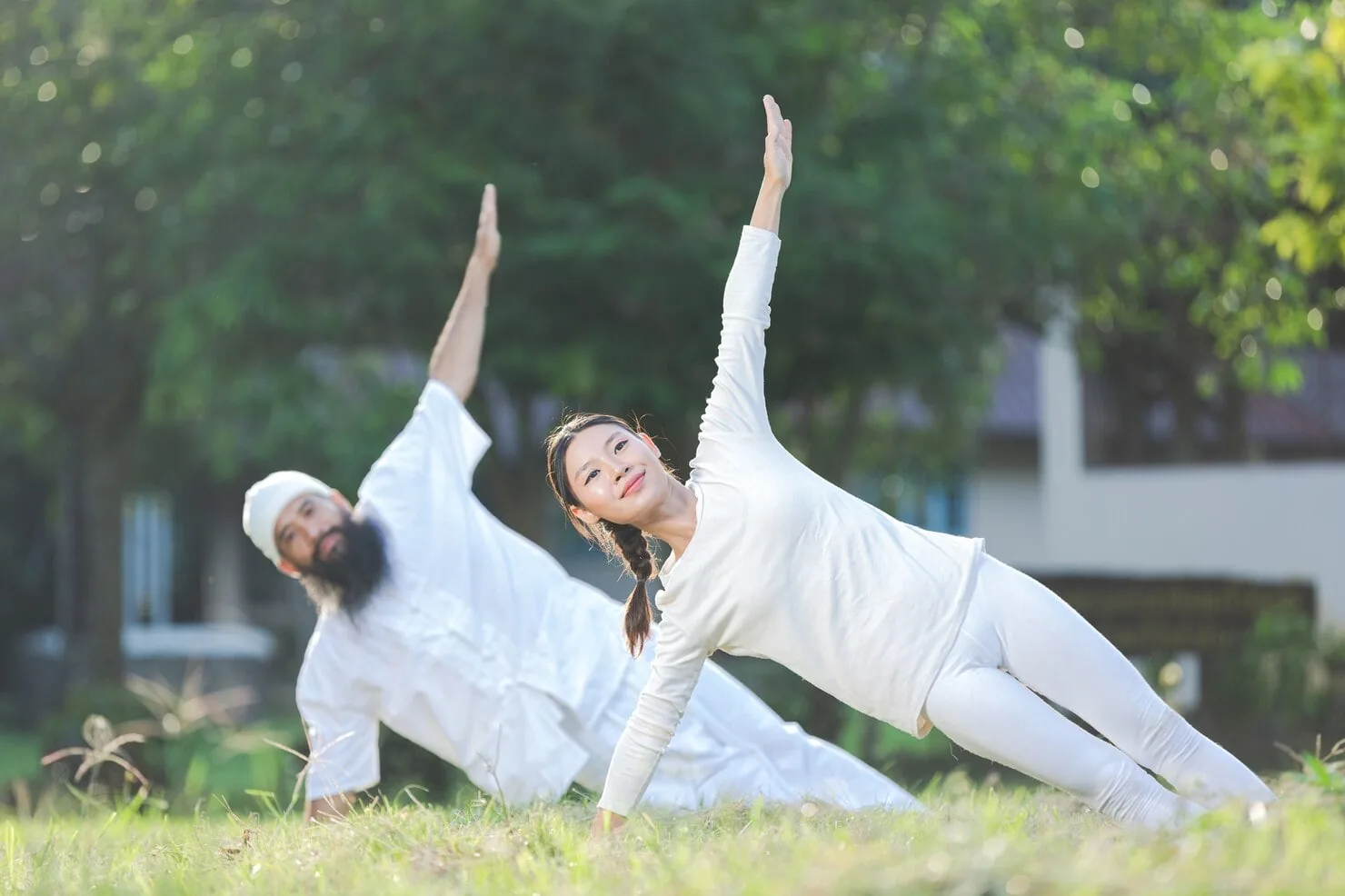 Two people doing yoga outdoors, representing preventive care and lifelong wellness